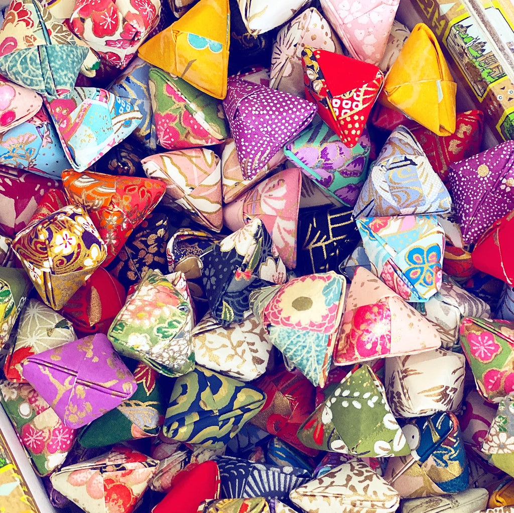 dozens of colorful folded origami in a box